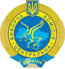 Ein gelber Ring in Form von Getreideähren umschließt den inneren gelben Ring mit der kyrillischen Inschrift „Zentrale Wahlkommission“. Er trägt oben das ukrainische Wappen. Zentral ist ein hellblauer Bereich zu sehen, der den Umriss der Ukraine bildet und eine gelbe Taube, die eine Waage im Schnabel hält.