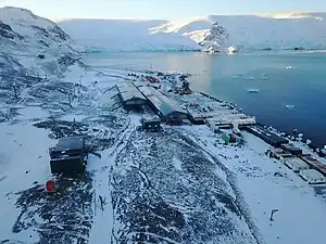 Blick von der Keller-Halbinsel mit der brasilianischen Estação Antártica Comandante Ferraz nach Norden auf die Mündung des Stenhouse-Gletschers (links) und des Ajax-Eisfalls (rechts) in die Bucht Visca Anchorage