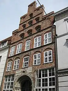Mengstr. 64, 16. Jh., zwischen den Stilen, gotisches Kalk­stein­portal aus dem 13.&nbsp;Jh.
