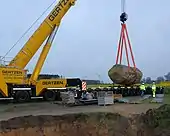Verlastung auf einen Tieflader mit dem Erdloch im Vordergrund