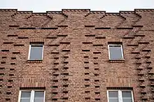 nach oben auseinanderlaufende Lisenen