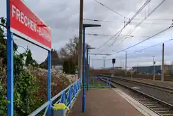 Bahnsteig am Bahnhof Frechen mit Stationsschild und mehreren Gleisen
