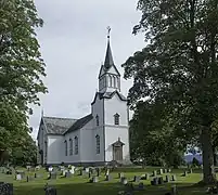 Foto einer weißen Holzkirche mit Friedhof im Vordergrund