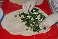 Aufbringen der Füllung (in diesem Fall Schafskäse, Spinat und Kräuter)