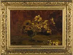 Das Gemälde im verzierten Goldrahmen stellt gelbe Blumen in einer Glasvase mit schlankem Stiel dar. Der Hintergrund ist verschwommen.