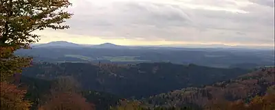 Blick vom Simmersberg (781&nbsp;m) im Thüringer Schiefergebirge auf die 24&nbsp;km entfernten Gleichberge. Rechts im Hintergrund die Hohe Rhön mit dem 67&nbsp;km entfernten Kreuzberg (927,8&nbsp;m), unmittelbar davor (halbrechts mittig) der 7&nbsp;km entfernte Ratscher Bergsee