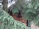 Glockenstuhl auf vier gusseisernen Stützen mit Glocke am Wirtschaftsgebäude des ehemaligen Schulgehöftes