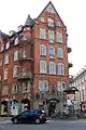 Hausschmuck mit Kindern, die in der Mitte an der Hand der Mutter sind und rechts einen Alten abschieben, in der Gothersgade 47 (ehemals Musikhus Kleinert), Kopenhagen