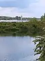 Blick über die Elbe auf die Radarstation NeßsandIm Vordergrund: eines der Absetzbecken des Wasserwerkes