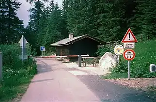 Blick vom österreichischen zum deutschen Staatsgebiet (1999)&nbsp;— mit dem näher zur Grenzlinie versetzten Schlagbaum