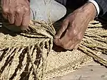 Handwerker, der einen Strohkorb flicht