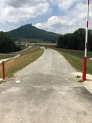 Damm (Nordansicht), der Staubereich liegt links, im Hintergrund die Burg Hohenzollern