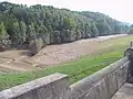 leeres Hochwasserrückhaltebecken Reinhardtsgrimma (nach dem Hochwasser im August 2002, der Schlamm an den Bäumen zeigt die Füllhöhe wenige Tage vorher)