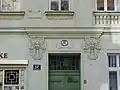 Tor von Nr. 104 (secessionistisch) in der Hollergasse mit dreiteiligen Mädchenmasken