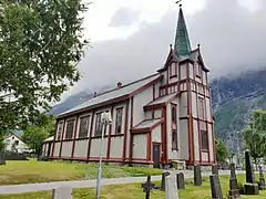 Foto einer Holzkirche in bergiger Umgebung