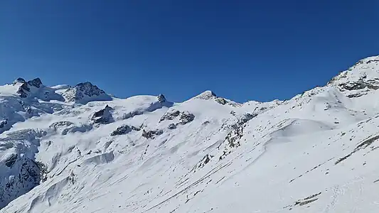 Punta Orientale della Sella, Punta Occidentale della Sella, Cima Sondrio, Piz Glüschaint, La Muongia und Il Chapütschin (v.&nbsp;l.&nbsp;n.&nbsp;r.), aufgenommen von Murtèl Sur (für Annotationen der einzelnen Berge aufs Bild klicken)