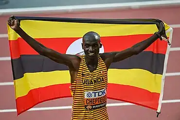 Joshua Cheptegei mit der ugandischen Landesfahne nach seinem dritten WM-Titel über 10.000 Meter