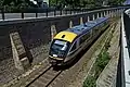 Kurz vor dem Tunnel in Kamenz, Linie RB 34. Die Fahrzeuge sind farblich noch im Aussehen des vorherigen Betreibers, lediglich wurde dessen Logo durch das der Mitteldeutschen Regiobahn überklebt. (Mai 2020)