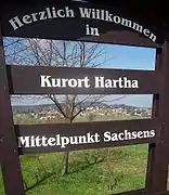 Blick durch die Begrüßungstafel auf den Ort