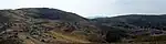 Landschaft mit Hügeln und Felsen.