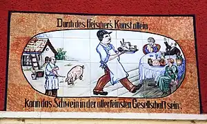Keramisches Wandbild an einer ehemaligen Fleischerei an der Ossietzkystraße