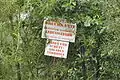 Warnschild mit Betretungsverbot im Gebüsch am Südufer