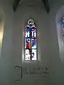 Zentrales Kirchenfenster, darunter Wandinschrift auf Sursilvan: "Jesus sagt: Ich bin der Weg, die Wahrheit und das Leben"