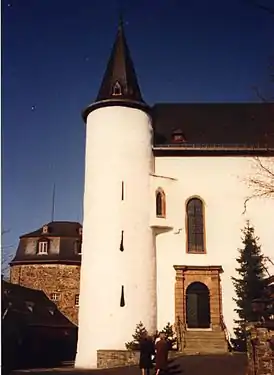 Glockenturm und Eingang zur Kirche; im Hintergrund links der Hexenturm