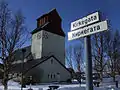 Kirche und Straßenschild auf Norwegisch und Russisch