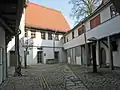 Innenhof mit Wasserpumpe und Hinterhaus