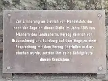 Tafelinschrift:Zur Erinnerung an Dietrich von Mandelsloh, dernach der Sage an dieser Stelle im Jahre 1385 vonMännern des Landesherrn, Herzog Heinrich vonBraunschweig und Lüneburg auf dem Wege zu einerBesprechung mit dem Herzog überfallen und er-stochen wurde, setzten ihm seine Gefolgsleutediesen Kreuzstein.