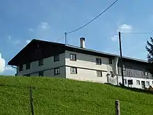 zweigeschossiger, verschindelter Einfirsthof mit Flachsatteldach