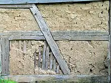 Lehmausfachungen, oben mit Lehmsteinen, unten mit abgewittertem Lehmbewurf und fregelegter Stakung