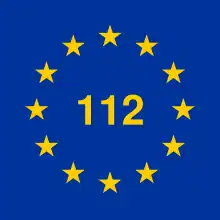 12 gelbe Stern im Kreis, in der Mitte „112“ im gleichen Gelb, blauer Hintergrund