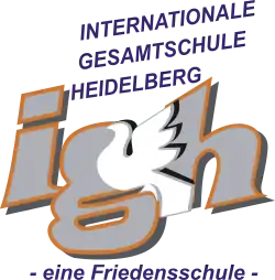 Die Buchstaben I, G und H umrahmen eine weiße Taube. Darüber der Schriftzug Internationale Gesamtschule Heidelberg", darunter steht „eine Friedensschule“.
