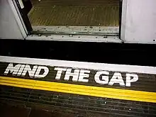Warnung „MIND THE GAP“ auf der Bahnsteigkante einer Station der London Underground