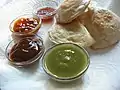 Vier verschiedenfarbige Saucen, mit Samosas