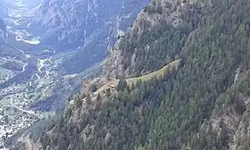 Blick von Wintergadmen in 1809 m ü. M. auf das Maiensäss Teli in 1611 m ü. M. Sichtbar sind das Teli-Kreuz, das Wohnhaus und die Stallung direkt oberhalb.