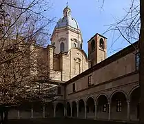 Erhaltener Teil des Kreuzgangs mit der dahinter angrenzenden Kirche