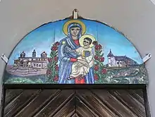 Maria mit lehrendem Jesus, Emailarbeit im Rundbogen einer Tür der Wallfahrtskirche Maria Schnee auf der Hochalm