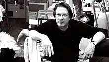 Der Maler Matthias Brock sitzend in seinem Atelier.