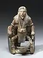 Sitzende Figur mit Tätowierungen