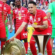 Noah Okafor mit dem Österreichischen Meisterteller und der Cup-Trophäe