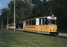 Ein Triebwagen der Kirnitzschtalbahn setzt um die beiden im Hintergrund sichtbaren Beiwagen um, an denen er gleich links vorbeifahren wird