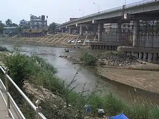 Freundschaftsbrücke am Moei-Fluss (Man beachte die Flüchtlinge, welche den Fluss mit einem Lastwagenreifen überqueren)
