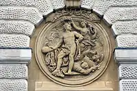 Victoria krönt den als Herkules dargestellten Ludwig XIV. mit einem Lorbeerkranz. Zu seinen Füßen liegt ein besiegter Soldat.
