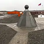 Dieses Denkmal befindet sich in der Nähe der Stationen „Presidente Eduardo Frei“, „Bellingshausen“ und Escudero auf der Fildes-Halbinsel, King George Island. Die Tafel am Fuß des Denkmals erinnert an die Unterzeichner des Antarktisvertrags. Das Denkmal besteht aus vier Gedenktafeln in den Amtssprachen des Antarktisvertrags. Der Text auf den im Februar 2011 installierten Tafeln lautet: „Dieses historische Denkmal, gewidmet dem Gedenken an die Signatarstaaten des Antarktisvertrags, Washington D.C., 1959, ist auch eine Erinnerung an das Erbe des Ersten und des Zweiten Internationalen Polarjahrs (1882–1883 und 1932–1933) und des Internationalen Geophysikalischen Jahres (1957–1958), das dem Antarktisvertrag vorausging, und erinnert an das Erbe der internationalen Zusammenarbeit, die zum Internationalen Polarjahr 2007–2008 geführt hat.“ Das Denkmal wurde entworfen und gebaut vom US-Amerikaner Joseph W. Pearson, der es Chile anbot. Es wurde im Jahr 1999 anlässlich des 40. Jahrestages der Unterzeichnung des Antarktisvertrags enthüllt.
