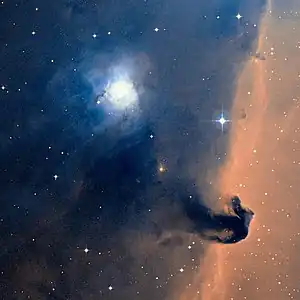 NGC 2023 (bläulich, links oberhalb der Bildmitte) in der Nähe der Pferdekopfnebels (dunkel vor orangen Hintergrund, rechts unterhalb der Mitte) in einer Aufnahme der Digitized Sky Survey 2.