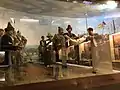 Verschiedene Personen als Puppen führen Kampfhandlungen aus.