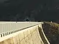 Der Tunnel von 2017 durchquert die Ausläufer der Lobspitzen. Im Vordergrund die Griffe einer Kletterroute an der Hauptstaumauer.